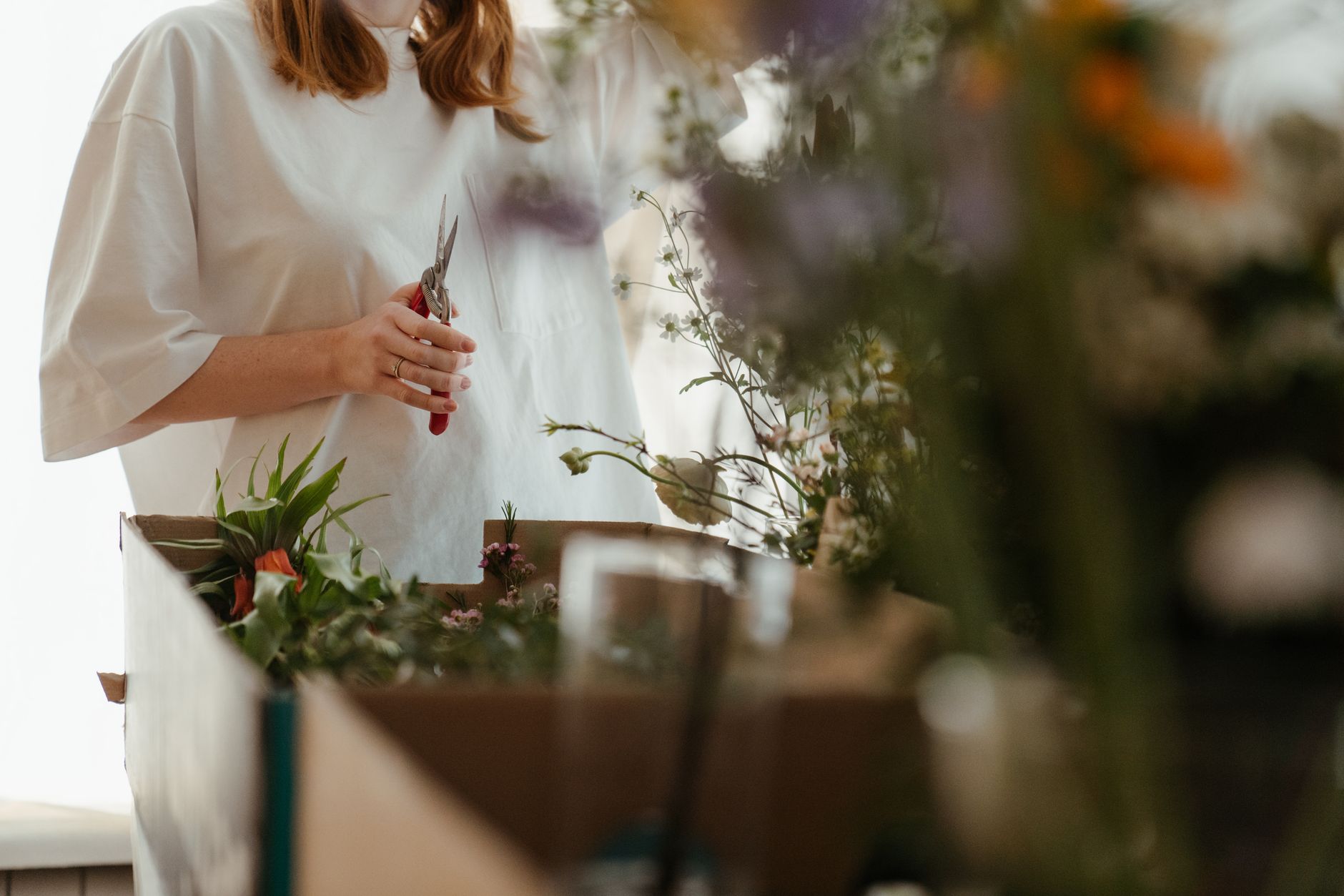 Bloembinder knipt verse bloemen bij aan de werkbank